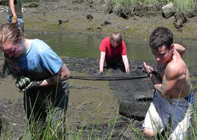 James - Dragging a tire out of the mud with a fellow volunteer during Clean the Bay day.
